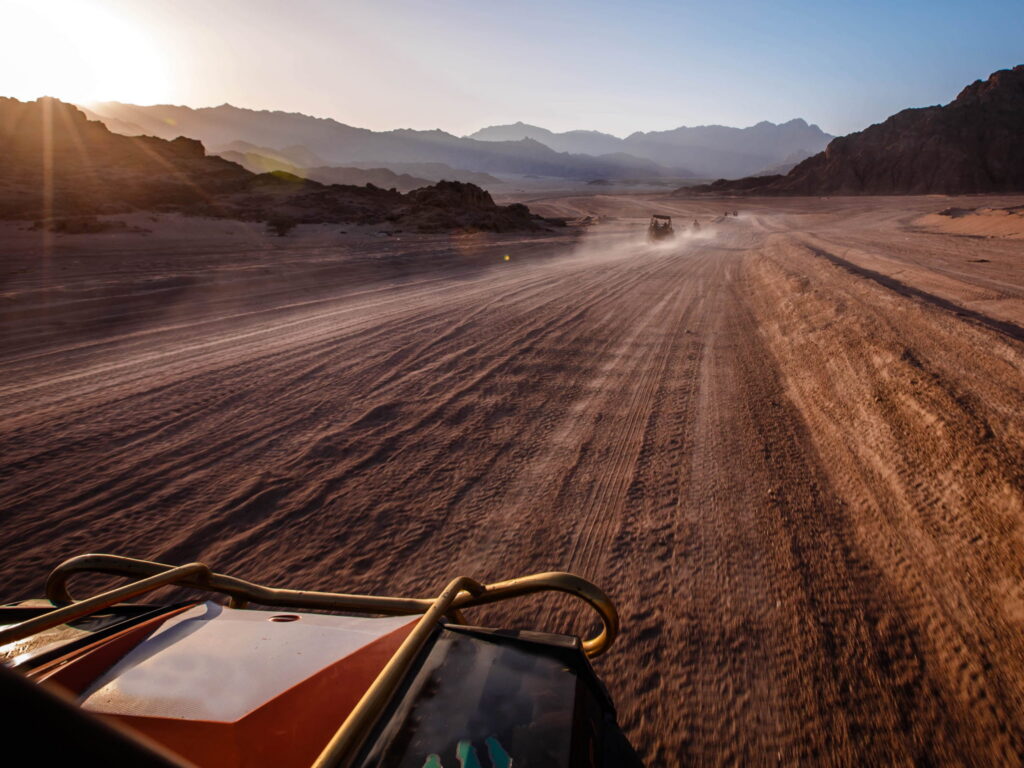Off-road trail stretching toward mountains at sunset