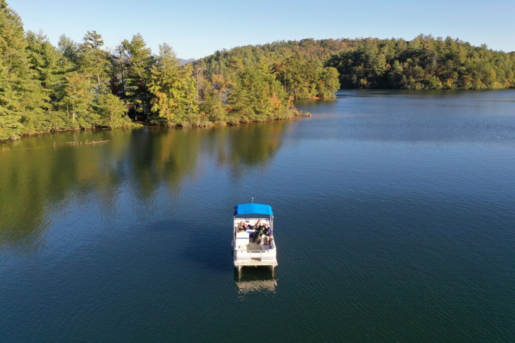 Boat crossing a calm lake surrounded by forest